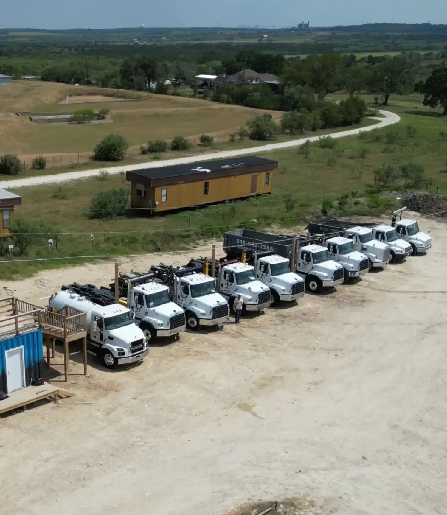 Aerial view of Dumpster Dogs roll-off dumpster trucks lined up at the yard