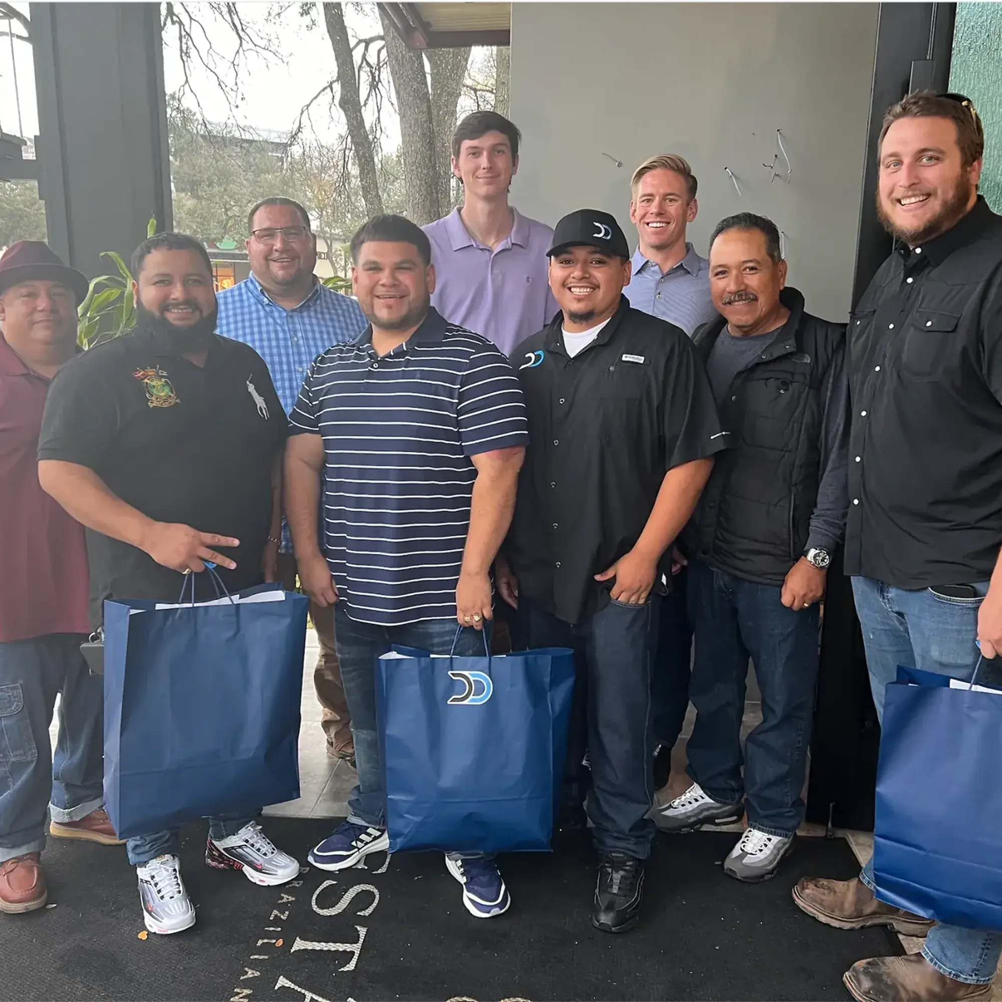 Dumpster Dogs team group photo holding gift bags